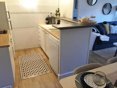 a small kitchen with a counter and a table and a couch at Les Jardins de Mistral Apartment in Aix-en-Provence
