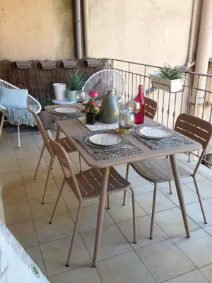 a wooden table with chairs and a table at Les Jardins de Mistral Apartment in Aix-en-Provence