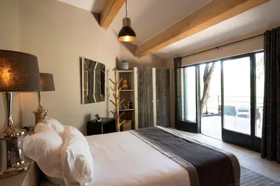 a bedroom with a bed and a large window at Hôtel La Maison de Crillon in Crillon-le-Brave
