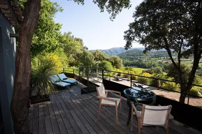 a deck with chairs and a table with a view at Hôtel La Maison de Crillon in Crillon-le-Brave