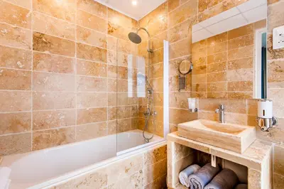 a bathroom with a tub and a sink at Hôtel de Charme Le Provence in Salon-de-Provence