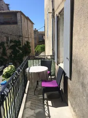 a balcony with a table and chairs on a building at Hotel Belvue in Sault-de-Vaucluse
