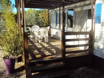 an open door to a deck with a table and chairs at B&B La Douloire in Pernes-les-Fontaines