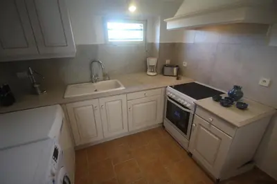 a kitchen with a sink and a stove top oven at Les Guillaume Rey in Oppède