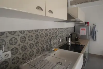 a kitchen with a dish drying rack on the wall at Les Guillaume Rey in Oppède