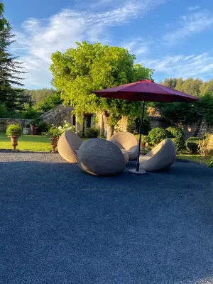 a group of chairs and an umbrella on the ground at Mas Serena in Ménerbes