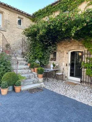 a stone building with stairs and a table with plants at Mas Serena in Ménerbes