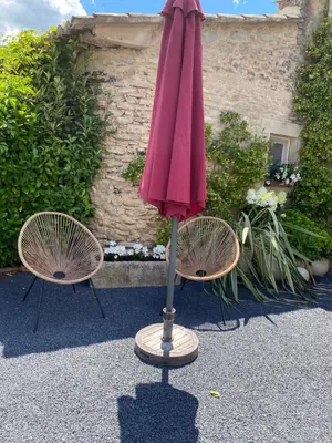 two chairs and an umbrella in front of a building at Mas Serena in Ménerbes