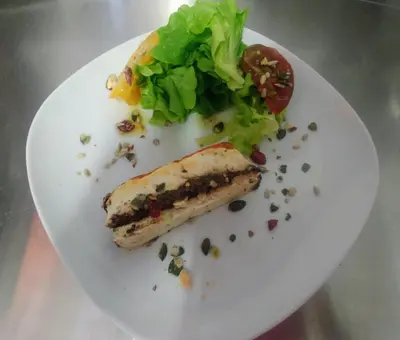 a white plate with a piece of fish and a salad at L'Aiguebelle in Céreste