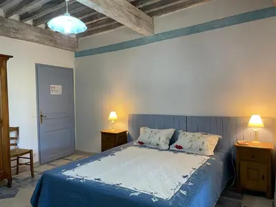 a bedroom with a bed with blue sheets and two lamps at Château de la Gabelle Férrassières in Ferrassières