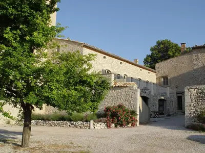a building with a tree in front of it at Château de la Gabelle Férrassières in Ferrassières