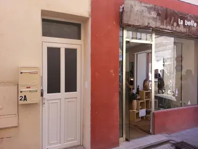 a white door on the side of a building at Colombe in LʼIsle-sur-la-Sorgue