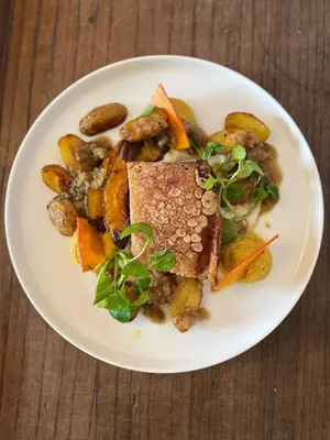 a white plate of food with vegetables and meat at Bar des Amis in Villars