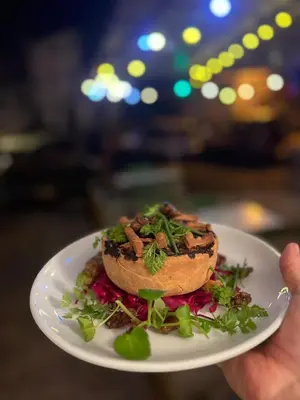 a person holding a plate with a sandwich on it at Bar des Amis in Villars