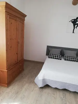 a bedroom with a bed and a wooden cabinet at Mas Saint Louis in Saignon