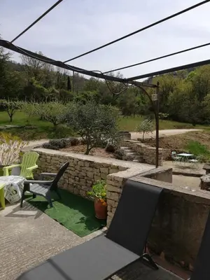 a patio with a bench and a stone wall at Mas Saint Louis in Saignon