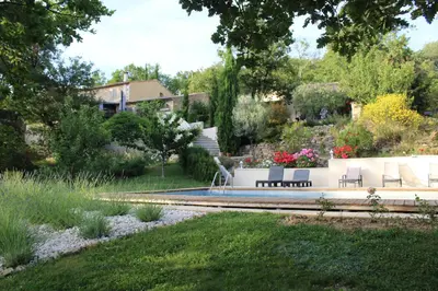 a garden with two benches and a fountain at Mas Auroma in Murs