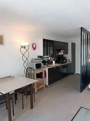 a kitchen with black and white cabinets and a table at Mas Auroma in Murs