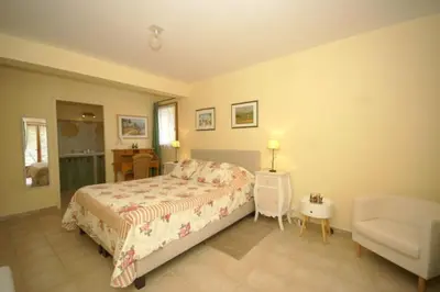 a bedroom with a bed and a chair at Les Cerises in Saint-Saturnin-les-Apt