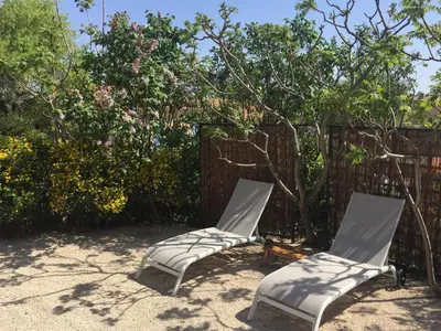 two chairs sitting in the sand in front of a fence at Bastidon la Cicada in Gordes
