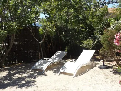 two white chairs sitting in a yard next to a fence at Bastidon la Cicada in Gordes