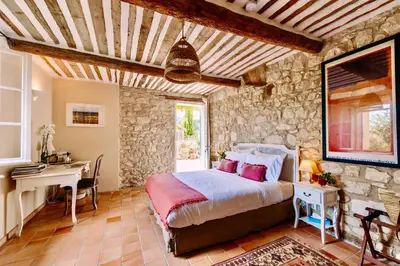 a bedroom with a bed and a table and a desk at Bastide Saint-Didier in Saint-Didier