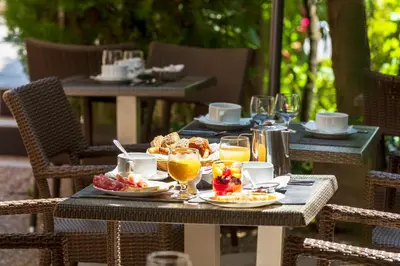 an outdoor table with food and drinks on it at Hôtel Le Mozart in Aix-en-Provence