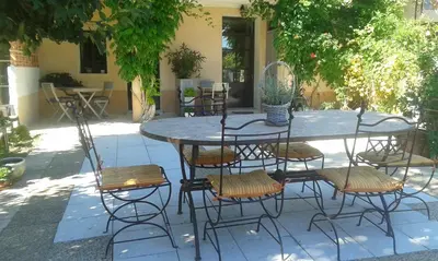 a table with chairs and a table and a table and chairs at Chambres d'Hôtes La Chrysalide in Loriol-du-Comtat