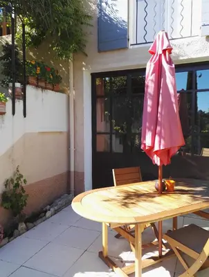 a pink umbrella sitting on top of a wooden table at Chambres d'Hôtes La Chrysalide in Loriol-du-Comtat