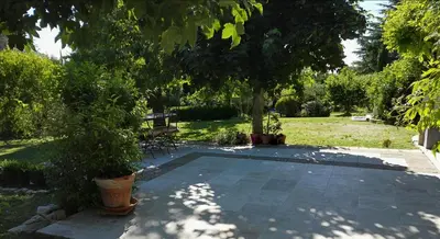 a garden with a tree and a table and benches at Chambres d'Hôtes La Chrysalide in Loriol-du-Comtat