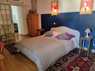 a bedroom with a large bed with a blue wall at Gîte en Provence in Entraigues-sur-la-Sorgue