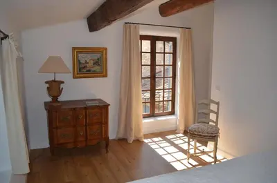 a bedroom with a bed and a chair and a window at Campagne Chastel in Aix-en-Provence