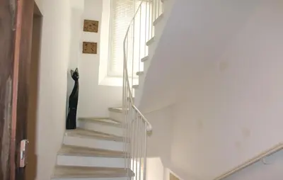 a staircase with a black cat sitting next to a window at Stunning Home In Reillanne With Wifi in Reillanne