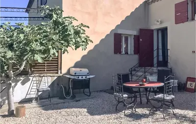 a table and chairs next to a building with a grill at 2 Bedroom Stunning Home In Apt in Apt