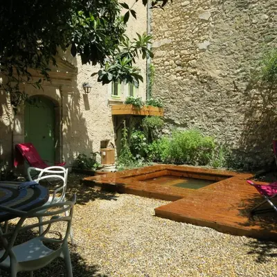 a patio with a table and chairs next to a building at La Buissonnière in Oppède