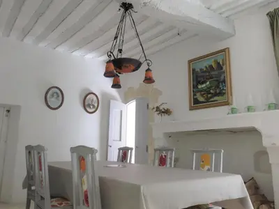 a dining room with a table and a chandelier at La Buissonnière in Oppède