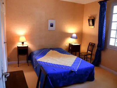 a bedroom with a bed and two chairs and a window at Les chambres d'Adeline - B&B in Murs