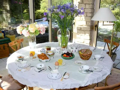 a white table with food and flowers on it at Les chambres d'Adeline - B&B in Murs
