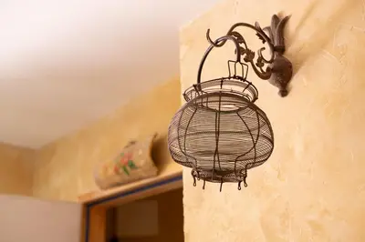 a bird cage on the side of a wall at Maison d'hôtes Une hirondelle en Provence in Roussillon
