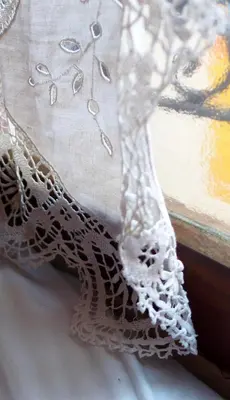 a close up of a white lace dress next to a window at Maison d'hôtes Une hirondelle en Provence in Roussillon