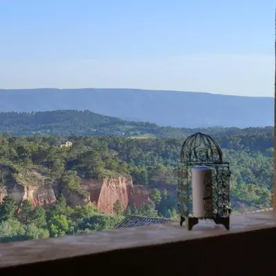 a bird cage sitting on a ledge with a view at Maison d'hôtes Une hirondelle en Provence in Roussillon
