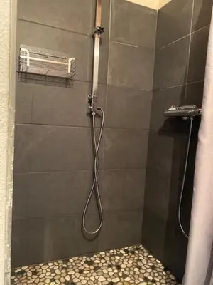 a shower with a hose in a shower stall at Petit studio Le Pigeonnier à 5 mn de Lourmarin in Puyvert