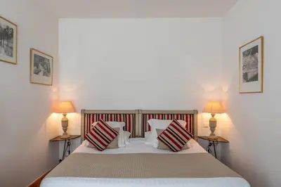 a bedroom with a large bed with two lamps at Le Clos Du Buis in Bonnieux