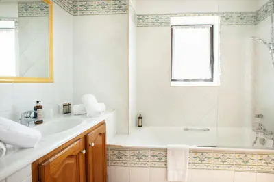 a white bathroom with a tub and a sink at Le Clos Du Buis in Bonnieux