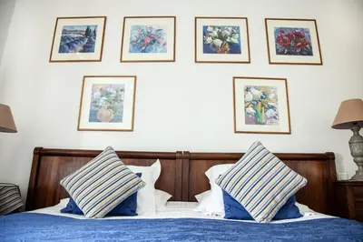 a bedroom with a bed with blue and white pillows at Le Clos Du Buis in Bonnieux