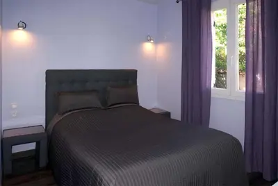 a bedroom with a bed with purple curtains and a window at Villa hortensia in Carpentras