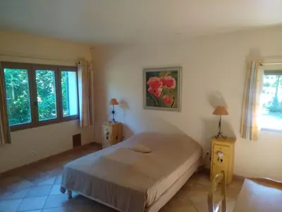 a bedroom with a bed and a painting on the wall at Lou Vergié Maison Provencale au pied du Luberon in Saint-Martin-de-Castillon