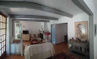 a living room with white walls and a room with a table at Lou Vergié Maison Provencale au pied du Luberon in Saint-Martin-de-Castillon