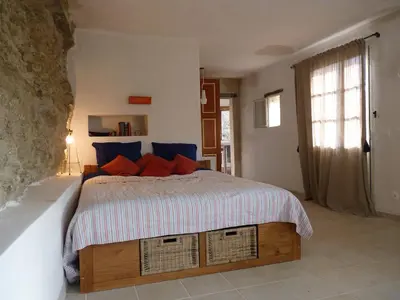 a stone house with a stone wall in a yard at La Baumo 1 und 2 in Le Beaucet