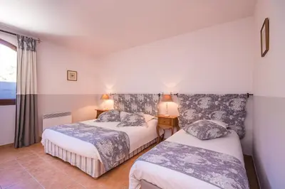 a bedroom with two beds and two lamps and a window at Le Relais Du Grand Logis in Mirabeau